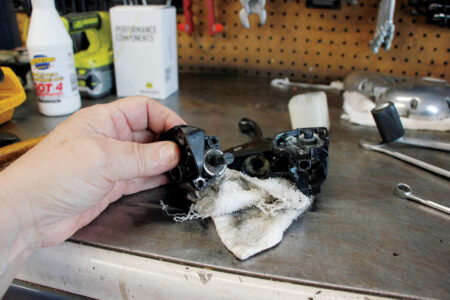 A hand holding the removed master cylinder